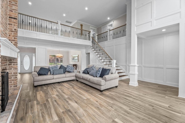 5523 Theall Rd, Houston, TX 77066 - living area featuring a decorative wall, ornamental molding, a towering ceiling, stairway, and light wood finished floors