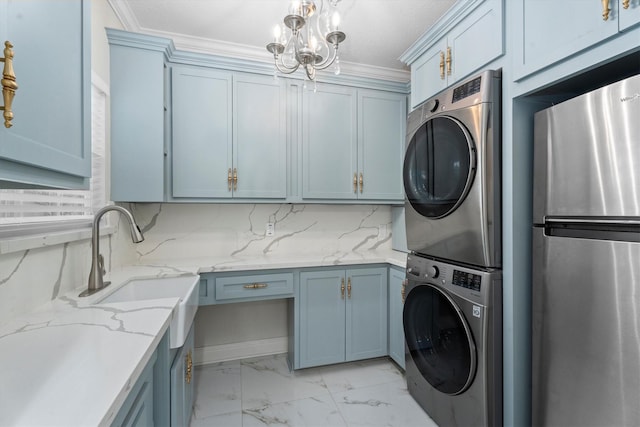 5523 Theall Rd, Houston, TX 77066 - washroom with stacked washer and clothes dryer, light marble finish flooring, ornamental molding, and a chandelier