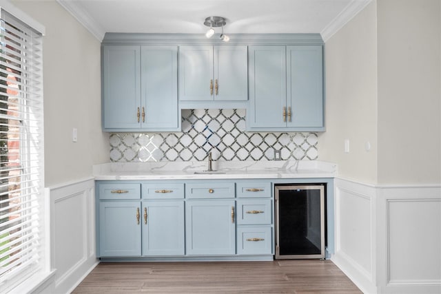5523 Theall Rd, Houston, TX 77066 - kitchen featuring beverage cooler, blue cabinets, healthy amount of natural light, light countertops, and a decorative wall