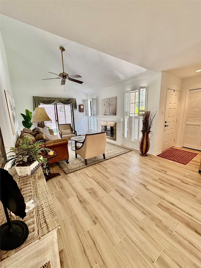 18526 Denise Dale Ln, Houston, TX 77084 - living area with light wood-style floors, a ceiling fan, a glass covered fireplace, vaulted ceiling, and baseboards