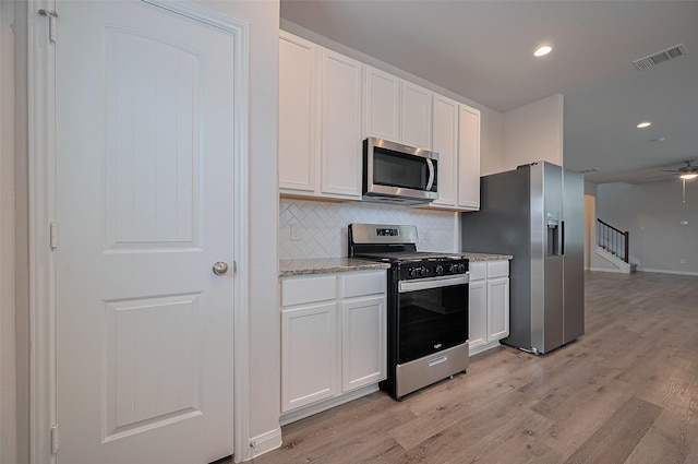 24710 Landolfi Dr, Katy, TX 77493 - kitchen featuring stainless steel appliances, white cabinetry, light wood-type flooring, decorative backsplash, and recessed lighting