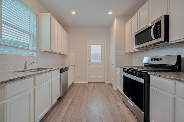 24710 Landolfi Dr, Katy, TX 77493 - kitchen with appliances with stainless steel finishes, a sink, light wood-style floors, white cabinets, and recessed lighting