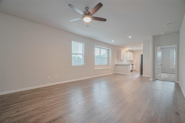 24710 Landolfi Dr, Katy, TX 77493 - unfurnished living room featuring a ceiling fan, light wood-style flooring, baseboards, and recessed lighting