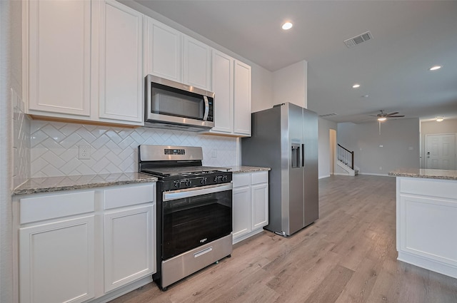 24710 Landolfi Dr, Katy, TX 77493 - kitchen with stainless steel appliances, decorative backsplash, white cabinetry, and recessed lighting