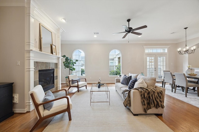 5405 Blossom St, Houston, TX 77007 - living room featuring plenty of natural light, light wood-style floors, ornamental molding, a ceiling fan, and a tile fireplace