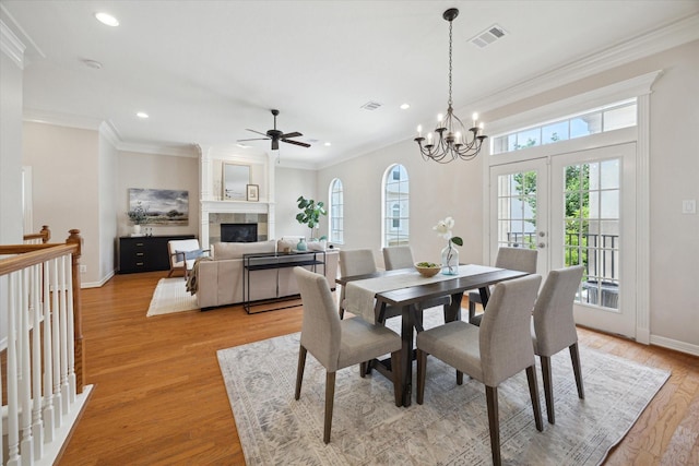 5405 Blossom St, Houston, TX 77007 - dining room featuring a ceiling fan, recessed lighting, light wood-type flooring, a tile fireplace, and ornamental molding