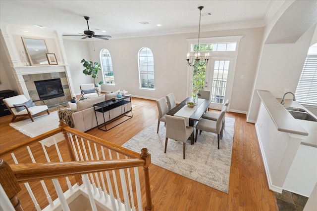 5405 Blossom St, Houston, TX 77007 - dining area featuring healthy amount of natural light, crown molding, light wood finished floors, a fireplace, and a chandelier