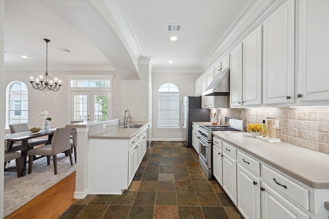 5405 Blossom St, Houston, TX 77007 - kitchen with stainless steel appliances, under cabinet range hood, a sink, baseboards, and tasteful backsplash