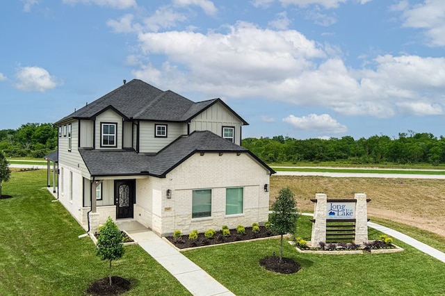 view of front of home featuring roof with shingles, board and batten siding, a front yard, and stone siding