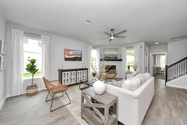2142 Emerald Diamond Ct, Fresno, TX 77545 - living room featuring light wood-style floors, ceiling fan, stairway, and baseboards