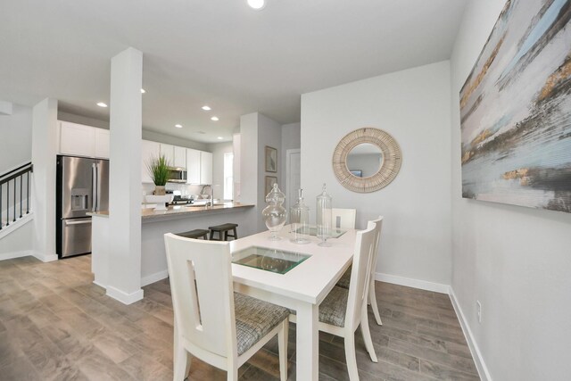 2142 Emerald Diamond Ct, Fresno, TX 77545 - dining room featuring light wood-style floors, recessed lighting, baseboards, and stairway