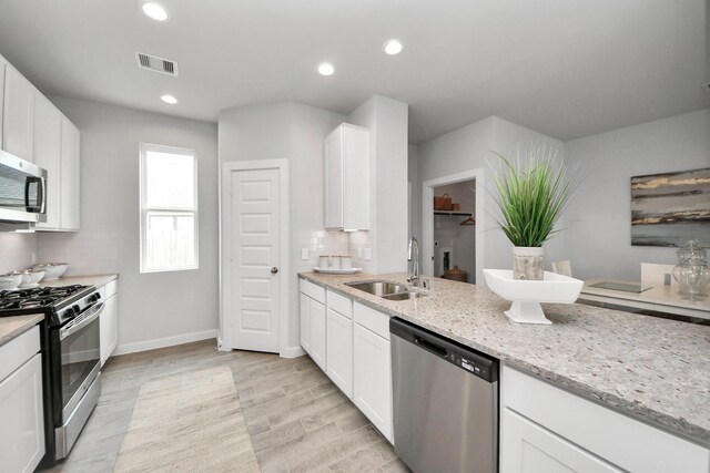 2142 Emerald Diamond Ct, Fresno, TX 77545 - kitchen with appliances with stainless steel finishes, a sink, white cabinets, light stone counters, and recessed lighting