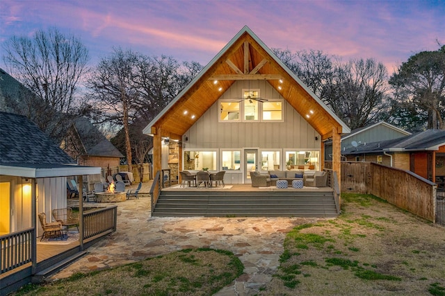175 Autumn Wood Trl, Gun Barrel City, TX 75156 - back of house at dusk featuring an outdoor living space with a fire pit, a wooden deck, board and batten siding, and a fenced backyard