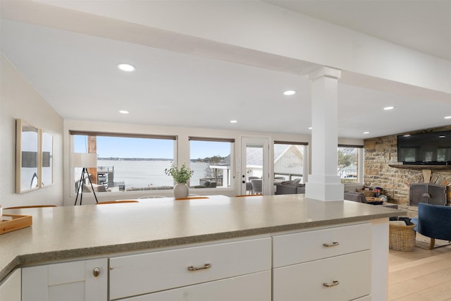 175 Autumn Wood Trl, Gun Barrel City, TX 75156 - kitchen with light wood finished floors, open floor plan, decorative columns, white cabinets, and recessed lighting