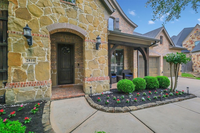 2810 Red Maple Dr, Katy, TX 77494 - view of exterior entry with concrete driveway, brick siding, stone siding, and an attached garage