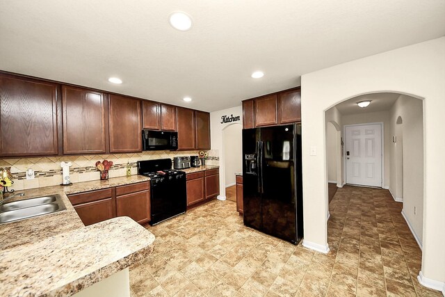 15319 Meandering Post Trl, Houston, TX 77044 - kitchen featuring black appliances, a sink, arched walkways, light countertops, and tasteful backsplash