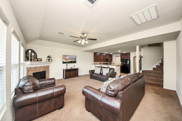 15319 Meandering Post Trl, Houston, TX 77044 - living room featuring light carpet, a ceiling fan, a fireplace, stairs, and lofted ceiling