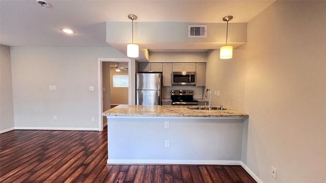 5333 Richmond Ave Unit 16, Houston, TX 77056 - kitchen featuring stainless steel appliances, a sink, gray cabinetry, a peninsula, and dark wood-style flooring