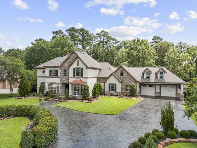 20806 Kings Crown Ct, Humble, TX 77346 - french country inspired facade featuring stone siding, stucco siding, decorative driveway, and a front yard