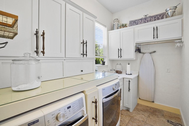 20806 Kings Crown Ct, Humble, TX 77346 - kitchen with washer / dryer, light stone finish floors, light countertops, white cabinets, and baseboards