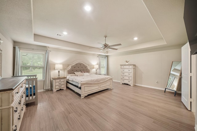 26410 Yaupon Crk, Magnolia, TX 77355 - bedroom with a tray ceiling, baseboards, light wood-type flooring, and recessed lighting