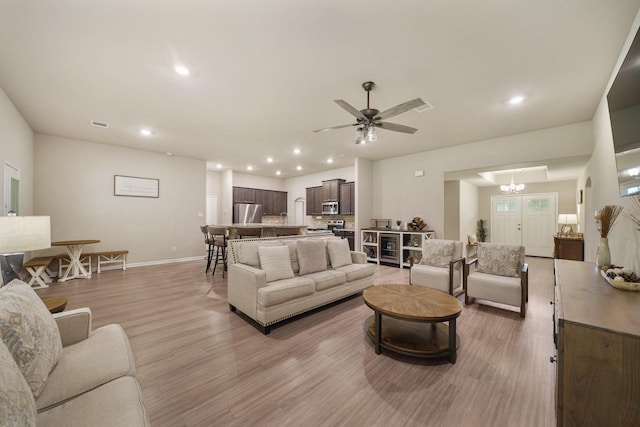 26410 Yaupon Crk, Magnolia, TX 77355 - living area with light wood-type flooring, baseboards, recessed lighting, ceiling fan, and a chandelier