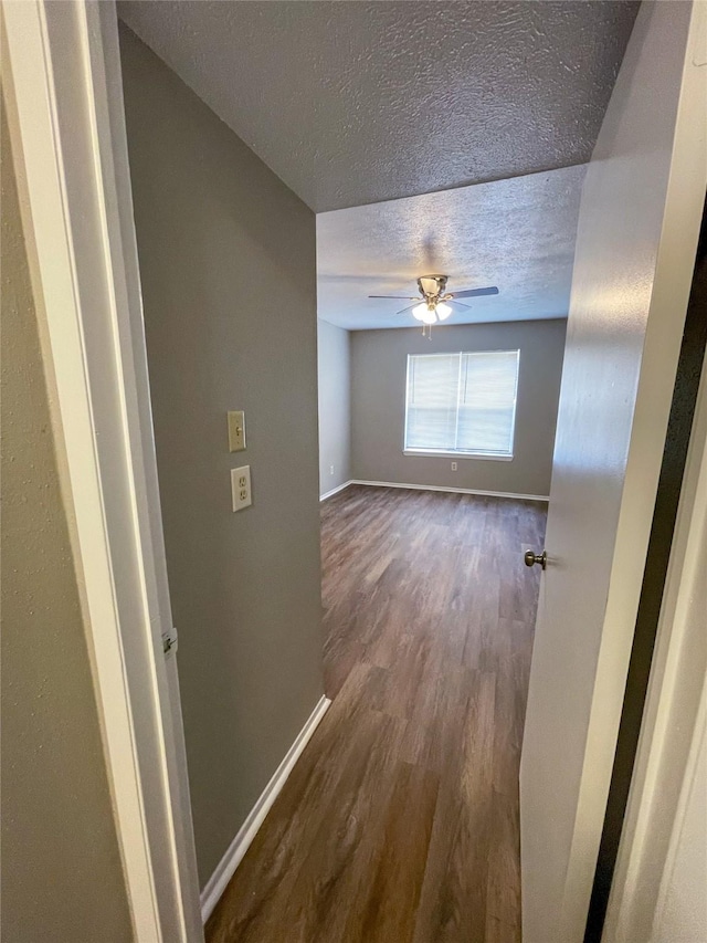 10555 Turtlewood Ct Unit 610, Houston, TX 77072 - empty room with a textured ceiling, dark wood-type flooring, baseboards, and a ceiling fan