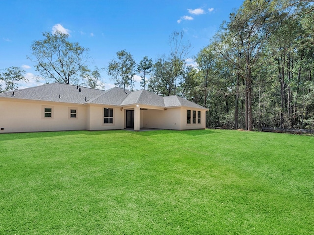 1197 Rd 660, Dayton, TX 77535 - rear view of property featuring a yard, stucco siding, and a shingled roof