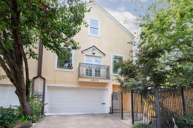 4015 Garrott St, Houston, TX 77006 - townhome / multi-family property with a garage, a balcony, driveway, and stucco siding