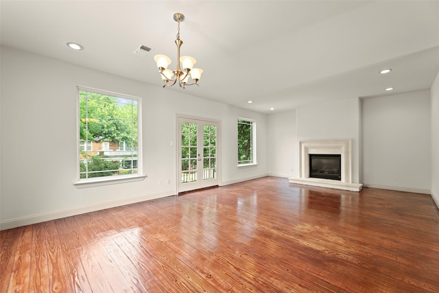 4015 Garrott St, Houston, TX 77006 - unfurnished living room with a chandelier, plenty of natural light, hardwood / wood-style flooring, recessed lighting, and baseboards