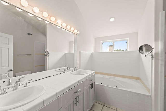 4015 Garrott St, Houston, TX 77006 - bathroom featuring a tub with jets, double vanity, and tile patterned flooring