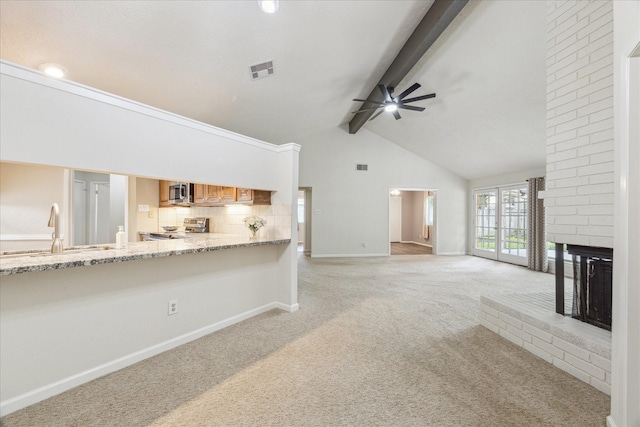 1018 W Castlewood Ave, Friendswood, TX 77546 - unfurnished living room with a sink, ceiling fan, light colored carpet, a brick fireplace, and beamed ceiling