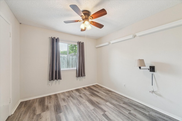 1018 W Castlewood Ave, Friendswood, TX 77546 - unfurnished room with wood finished floors, ceiling fan, a textured ceiling, and baseboards