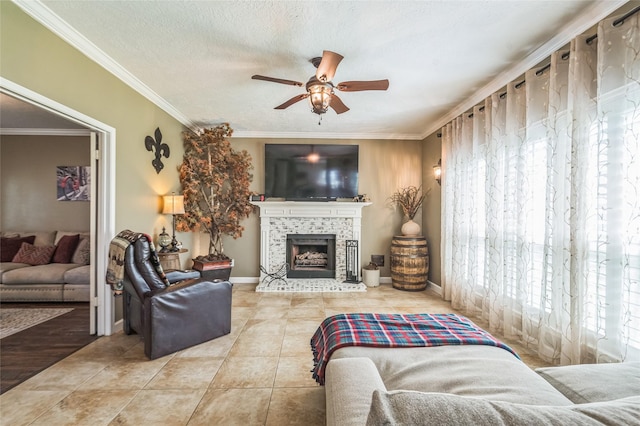 1914 Tipperary Dr, Deer Park, TX 77536 - living room with a ceiling fan, crown molding, a tiled fireplace, tile patterned flooring, and baseboards