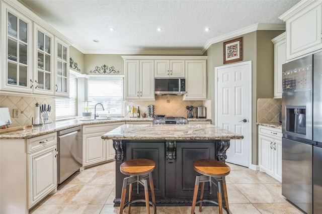 1914 Tipperary Dr, Deer Park, TX 77536 - kitchen featuring stainless steel appliances, a sink, decorative backsplash, a breakfast bar area, and light stone counters