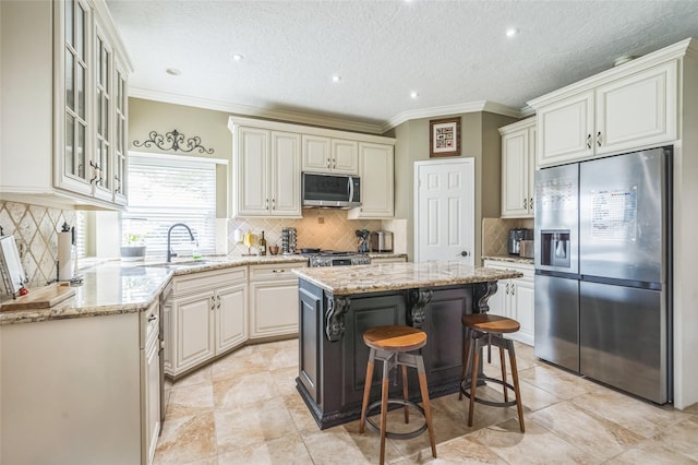 1914 Tipperary Dr, Deer Park, TX 77536 - kitchen with appliances with stainless steel finishes, tasteful backsplash, light stone countertops, a kitchen island, and ornamental molding