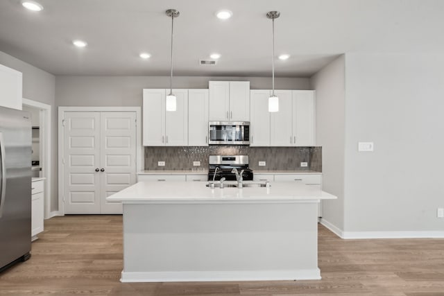18737 Bliss Pl, New Caney, TX 77357 - kitchen featuring appliances with stainless steel finishes, decorative backsplash, light countertops, light wood-type flooring, and recessed lighting