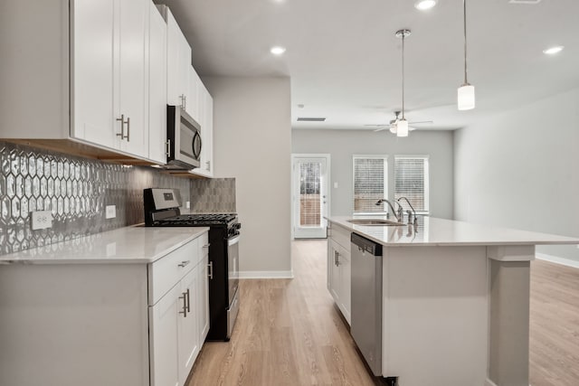 18737 Bliss Pl, New Caney, TX 77357 - kitchen with appliances with stainless steel finishes, a sink, light wood-type flooring, tasteful backsplash, and recessed lighting