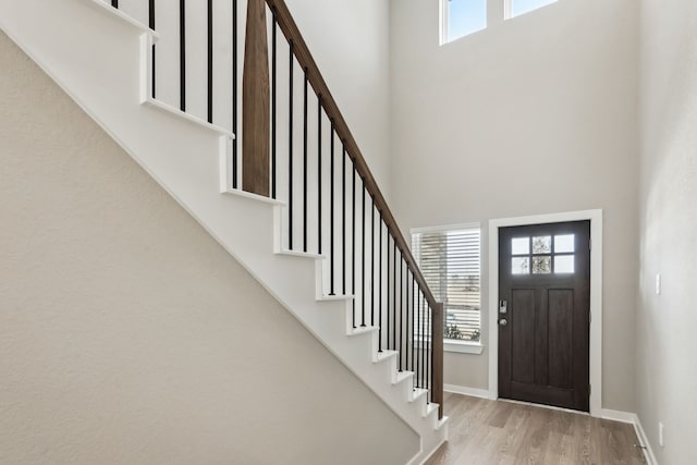 18737 Bliss Pl, New Caney, TX 77357 - entryway with stairway, a towering ceiling, wood finished floors, and baseboards