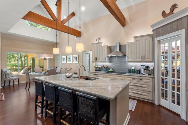 181 Saint Andrews Dr, Mabank, TX 75156 - kitchen featuring wall chimney range hood, a sink, black electric cooktop, high vaulted ceiling, and light stone countertops