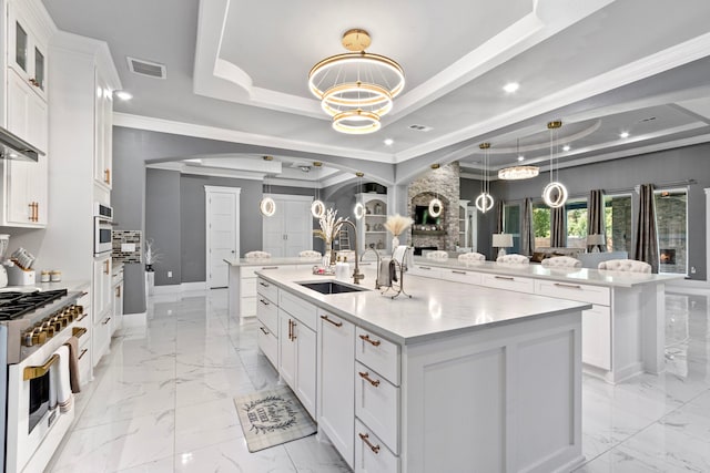 807 Steele Rd Unit A, Highlands, TX 77562 - kitchen with stainless steel range with gas cooktop, arched walkways, a sink, light marble finish floors, and a large island with sink
