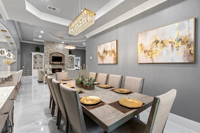 807 Steele Rd Unit A, Highlands, TX 77562 - dining area with a raised ceiling, light marble finish floors, crown molding, baseboards, and a stone fireplace