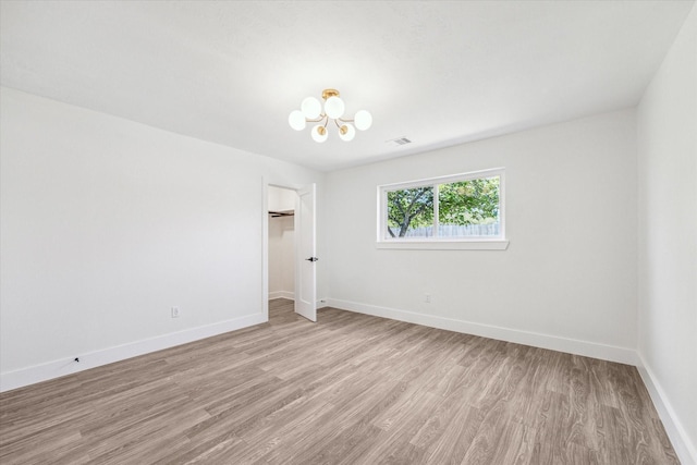 10830 Bob White Dr, Houston, TX 77096 - unfurnished room with a chandelier, light wood-style floors, and baseboards