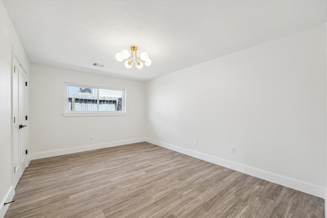 10830 Bob White Dr, Houston, TX 77096 - empty room featuring a chandelier, light wood-type flooring, and baseboards