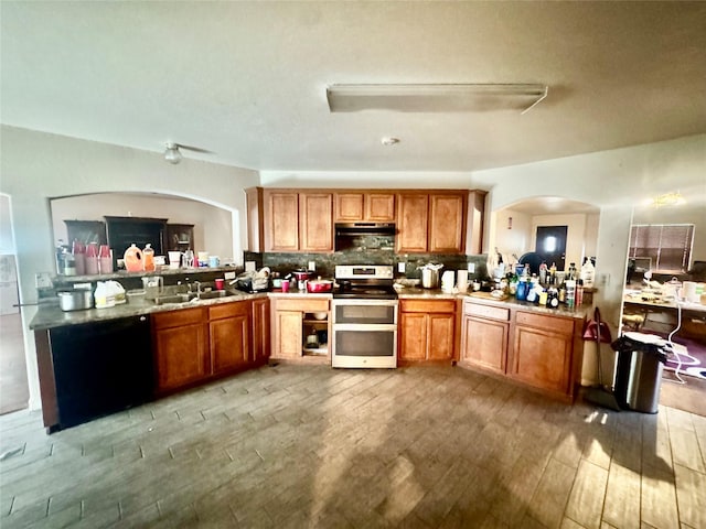 939 Cormorant, San Antonio, TX 78245 - kitchen featuring double oven range, under cabinet range hood, light wood-style flooring, and brown cabinets