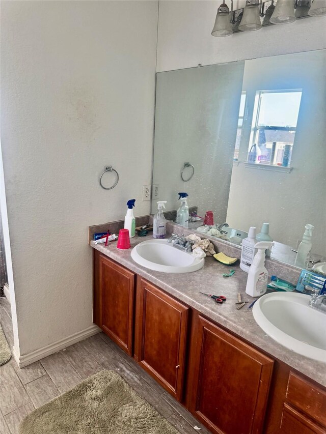 939 Cormorant, San Antonio, TX 78245 - bathroom with double vanity, wood finished floors, and baseboards
