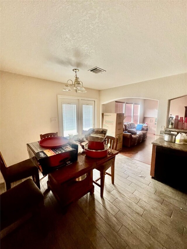 939 Cormorant, San Antonio, TX 78245 - dining room featuring wood finished floors, a textured ceiling, a chandelier, and healthy amount of natural light