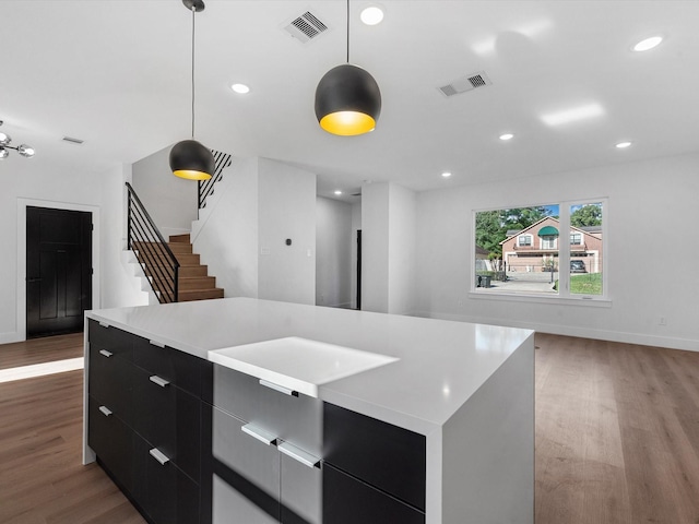 10732 Twin Oaks Dr, Conroe, TX 77385 - kitchen featuring modern cabinets, wood finished floors, dark cabinetry, light countertops, and recessed lighting