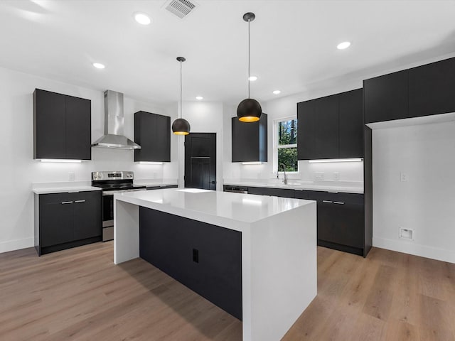 10732 Twin Oaks Dr, Conroe, TX 77385 - kitchen featuring wall chimney range hood, dark cabinetry, stainless steel range with electric stovetop, a sink, and recessed lighting