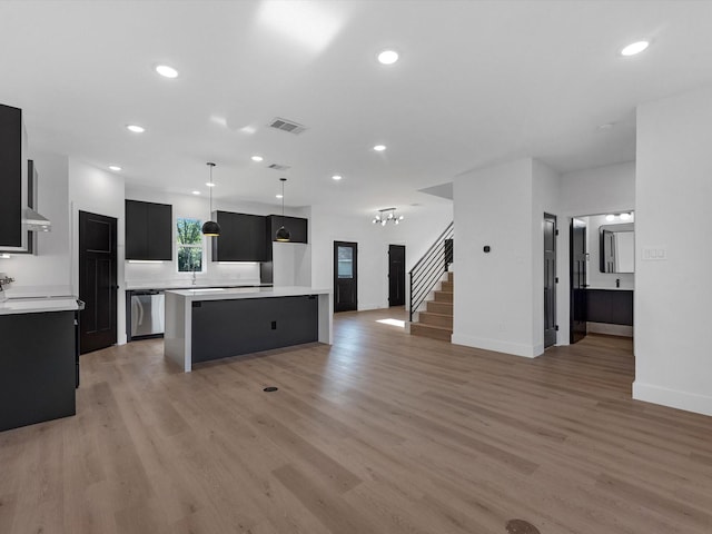 10732 Twin Oaks Dr, Conroe, TX 77385 - kitchen featuring dishwasher, dark cabinetry, light countertops, a center island, and light wood finished floors